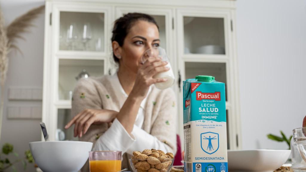 Una mujer tomando un vaso de leche Pascual Salud.