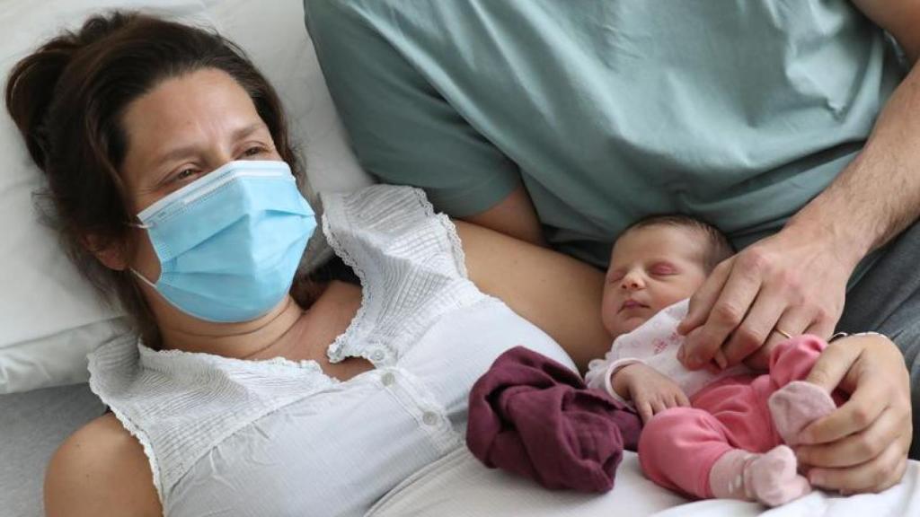 Una mujer que dio positivo antes de dar a luz, junto a su bebé en un hospital de Bruselas.