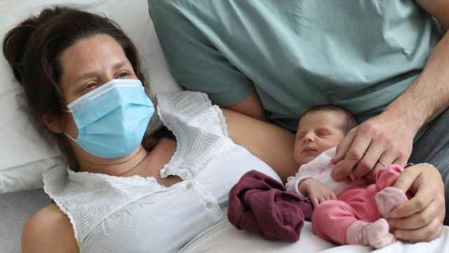 Imagen de archivo de una mujer que dio positivo antes de dar a luz junto a su bebé, en un hospital de Bruselas.