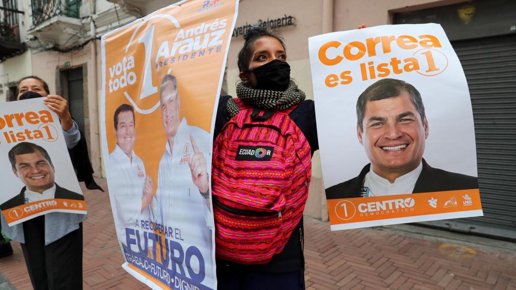 Simpatizantes del candidato a la presidencia Andrés Arauz (fuera de cuadro) participan en una caminata.