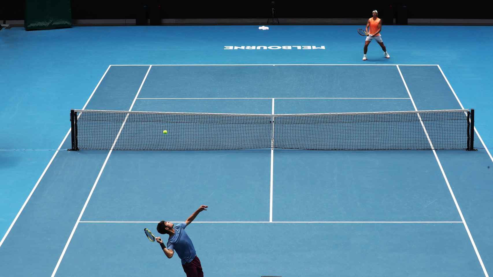 Carlos Alcaraz sirviendo y Rafa Nadal restando en una sesión de entrenamiento en el Open de Australia