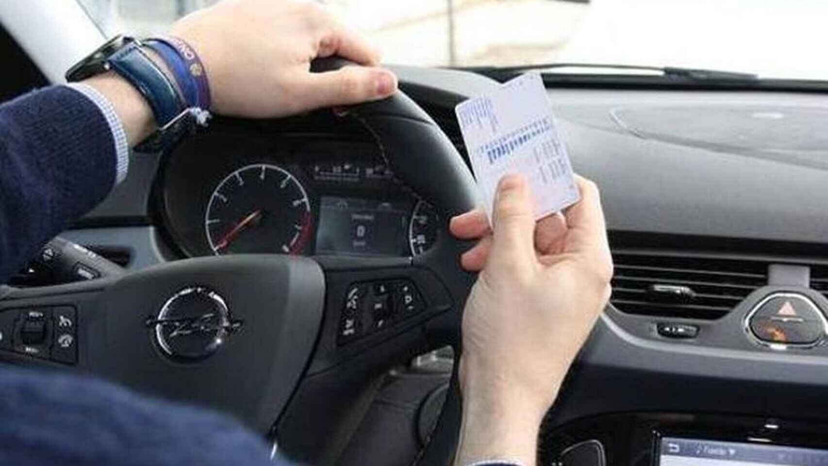 Un conductor sujeta su carné de conducir.