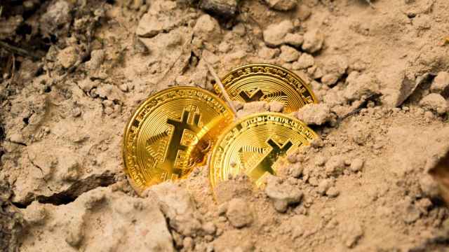 Monedas de bitcoin semienterradas.
