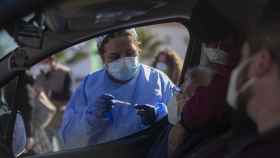 Una mujer mayor de 90 años recibe desde el coche la vacuna de Pfizer contra la Covid-19, en una carpa habilitada en la explanada del centro de salud del municipio Lora del Río. (María José López / EP)