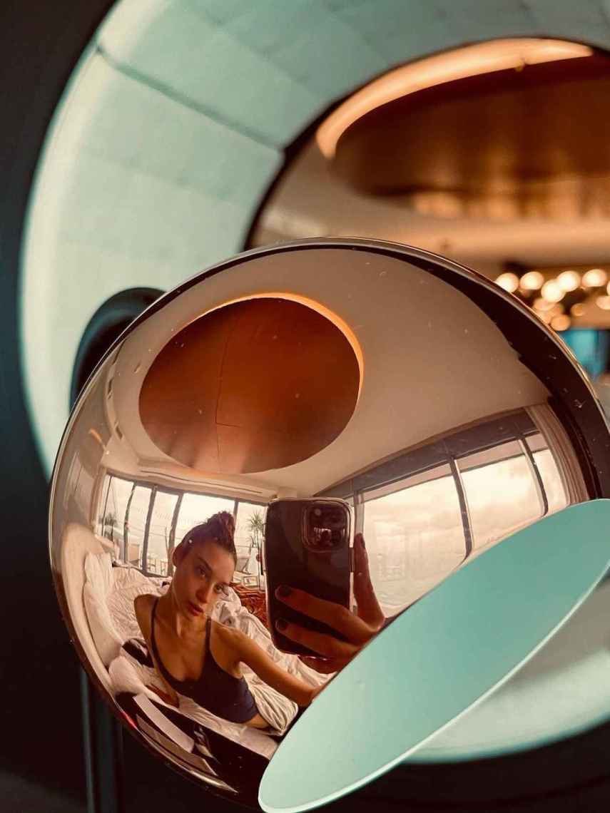 María Pedraza, reflejada en una de las lámparas de diseño de su lujosa suite en Barcelona.