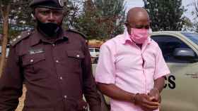 Paul Rusesabagina, esposado, camino del tribunal.