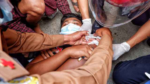 Un hombre en el suelo herido en una de las protestas en Mandalay, Birmania.