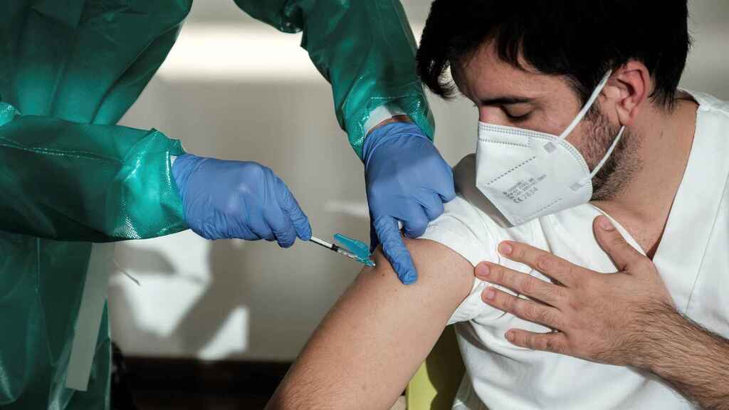 Un sanitario vacuna a un paciente.