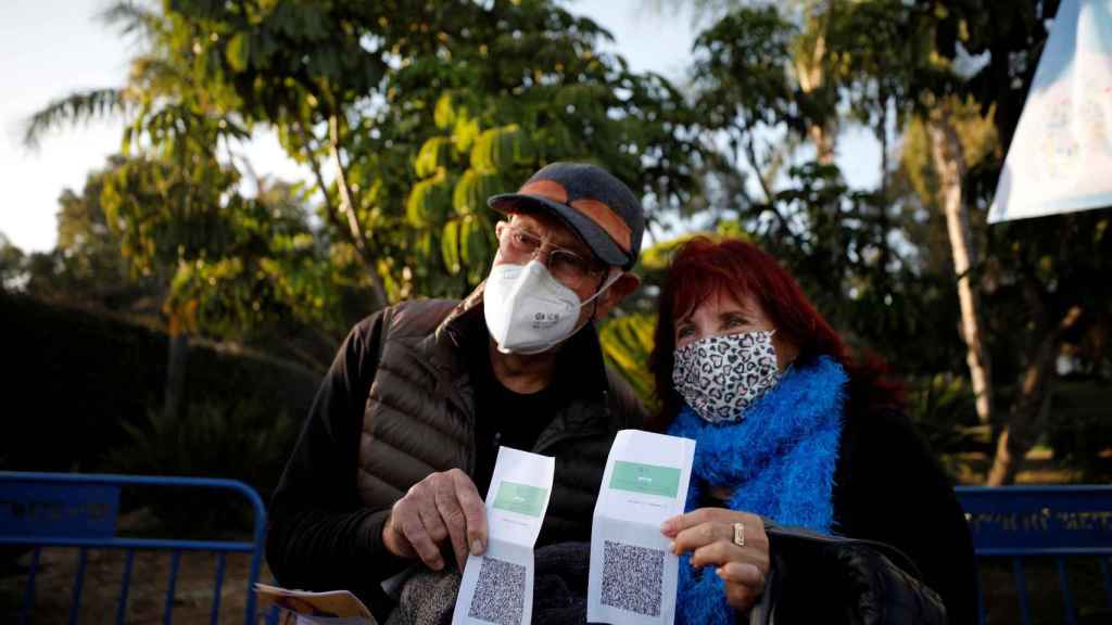 Dos ciudadanos israelíes muestran su ‘pase verde’, un certificado de vacunación.