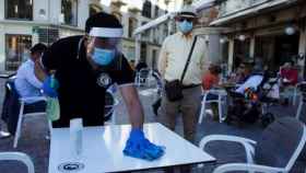 Un camarero limpia una mesa en una terraza de Madrid. Efe
