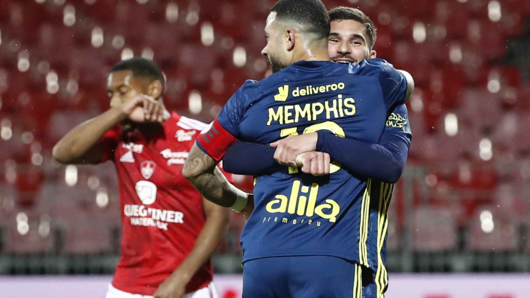 Houssem Aouar abraza a Memphis Depay en un partido del Olympique de Lyon