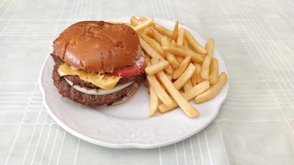 La nueva hamburguesa de Burger King, la 'Queen Cheese', emplatada junto a unas patatas fritas.