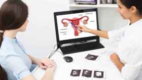 Una ginecóloga muestra el dibujo de un útero a una paciente.