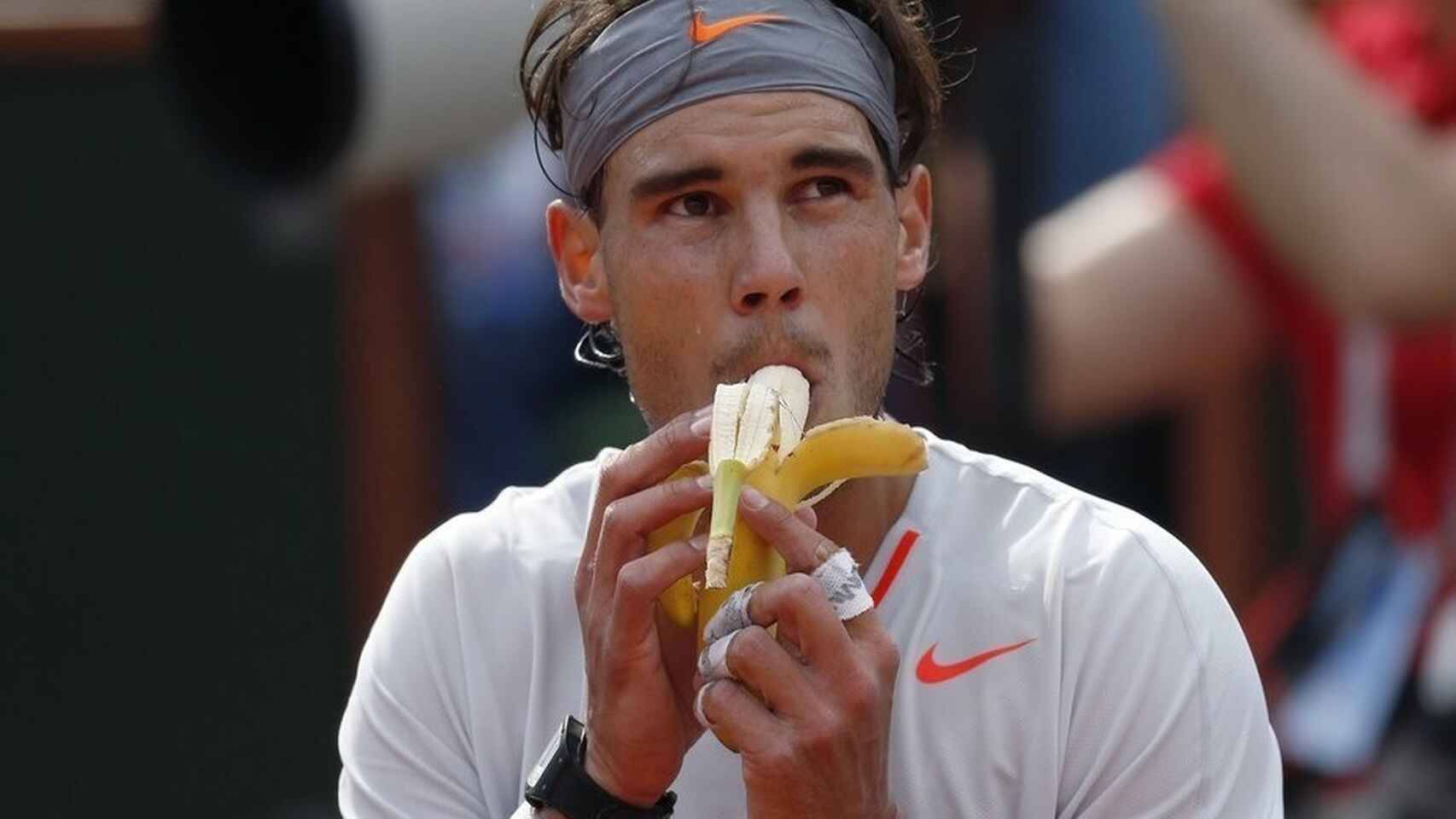 Rafa Nadal tomando un plátano durante el descanso de un partido.