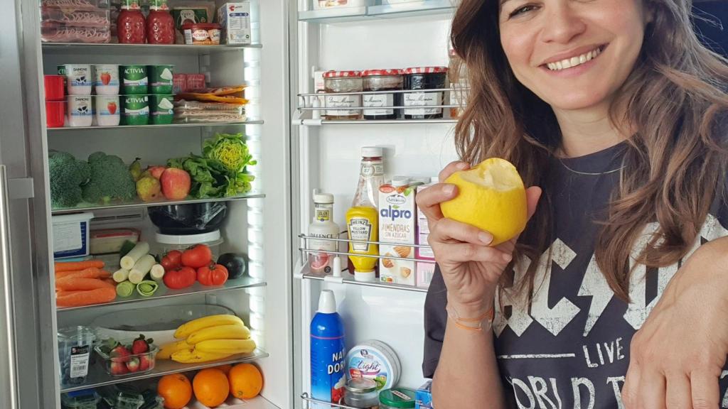 Fabiola Martínez, junto a su nevera, cargada de frutas y verduras.
