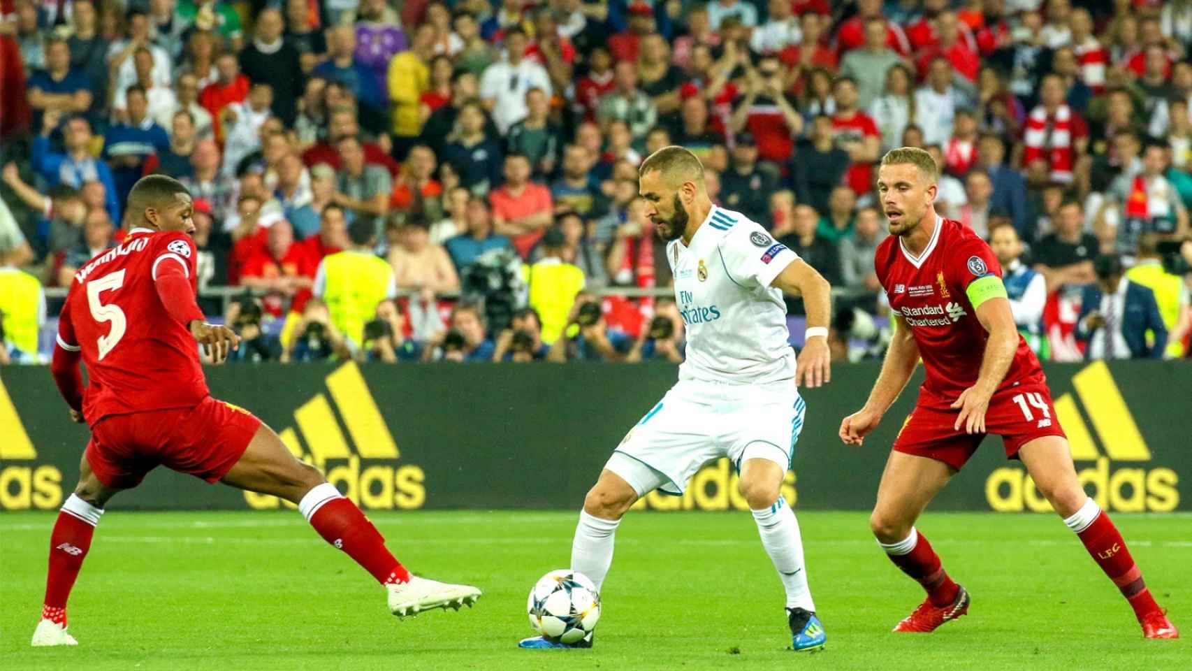 Benzema protege un balón entre Wijnaldum y Henderson en la final de la Champions de 2018