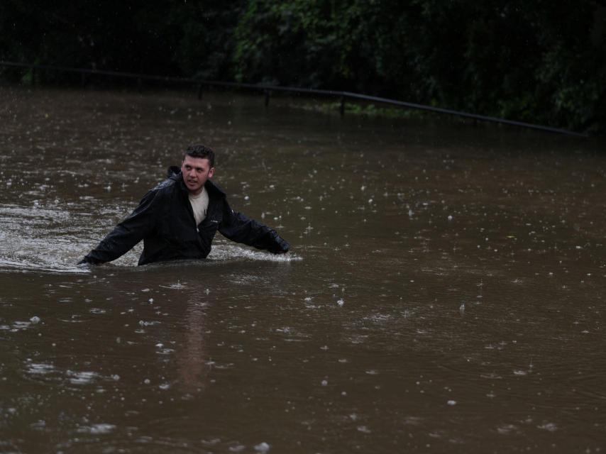 Un hombre lucha por llegar a su casa en medio de las inundaciones.