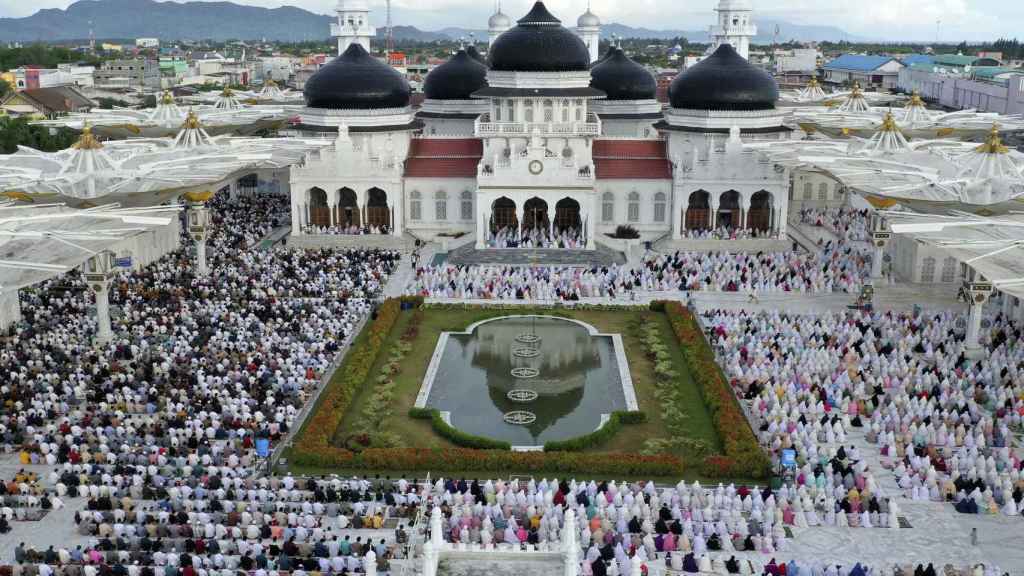 Un grupo de musulmanes reza ante la Gran Mezquita Baiturrahman, en Banda Aceh (Indonesia)