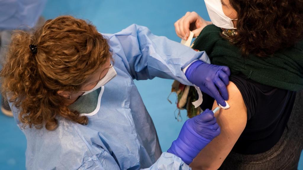 Una sanitaria vacunando a una mujer en Sevilla.