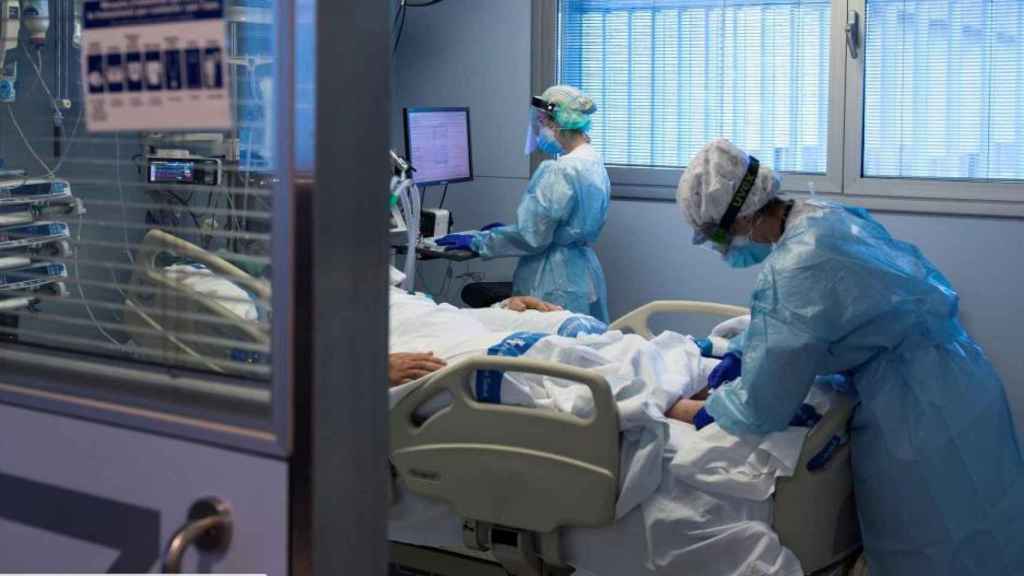 Personal sanitario atendiendo a un paciente ingresado en la UCI.