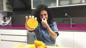 Una mujer con unas naranjas en la mano.