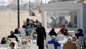 Distintos clientes disfrutan de una terraza en la playa de la Malvarrosa en Valencia.