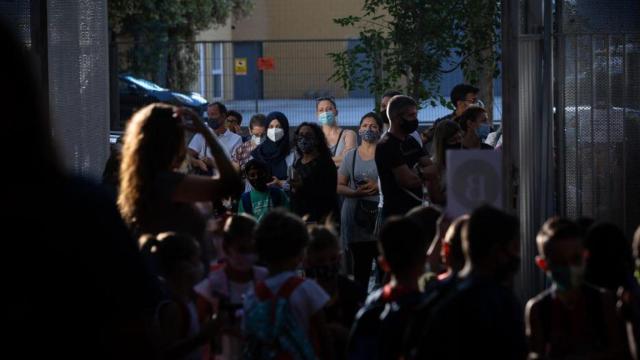 Padres y alumnos esperan a las puertas de un colegio en Cataluña.