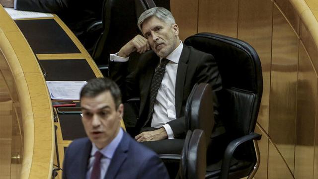 El ministro del Interior, Fernando Grande-Marlaska, escucha la intervención del presidente del Gobierno, Pedro Sánchez, en un pleno en el Senado.