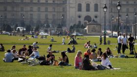 Decenas de personas disfrutan del buen tiempo cerca de Los Inválidos, en París.