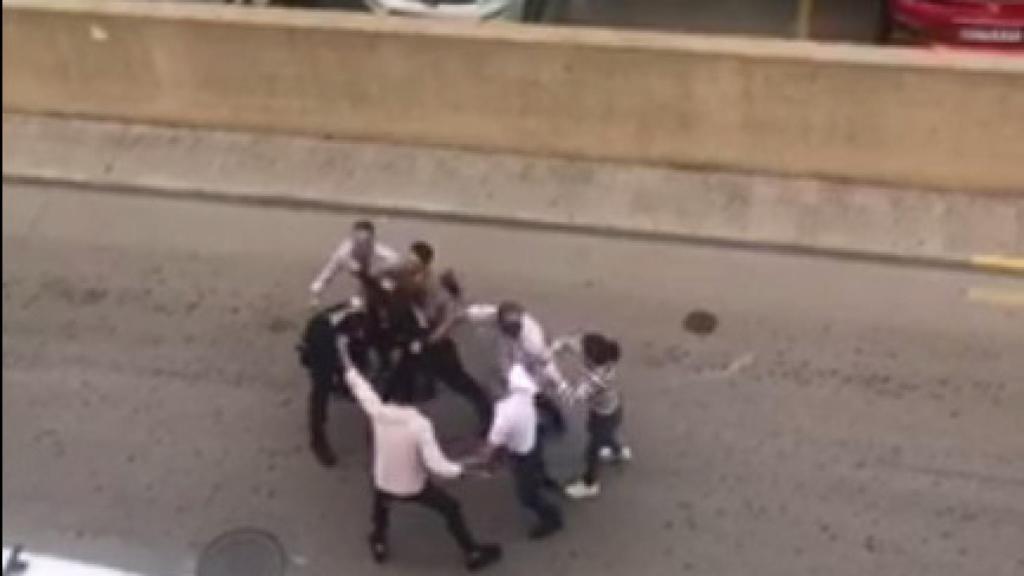 Momento en el que uno de los participantes en la fiesta agrede a uno de los agentes.
