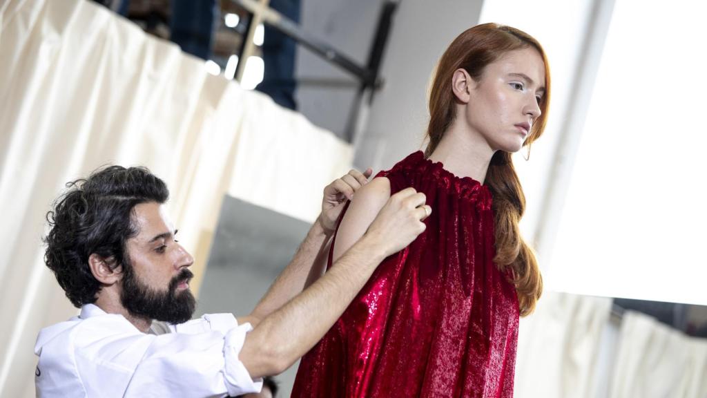 Moisés preparando a una de sus modelos antes de un desfile en enero de 2020.