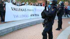 La Policía Nacional frente a los manifestantes en Vallecas durante en el acto de Vox.