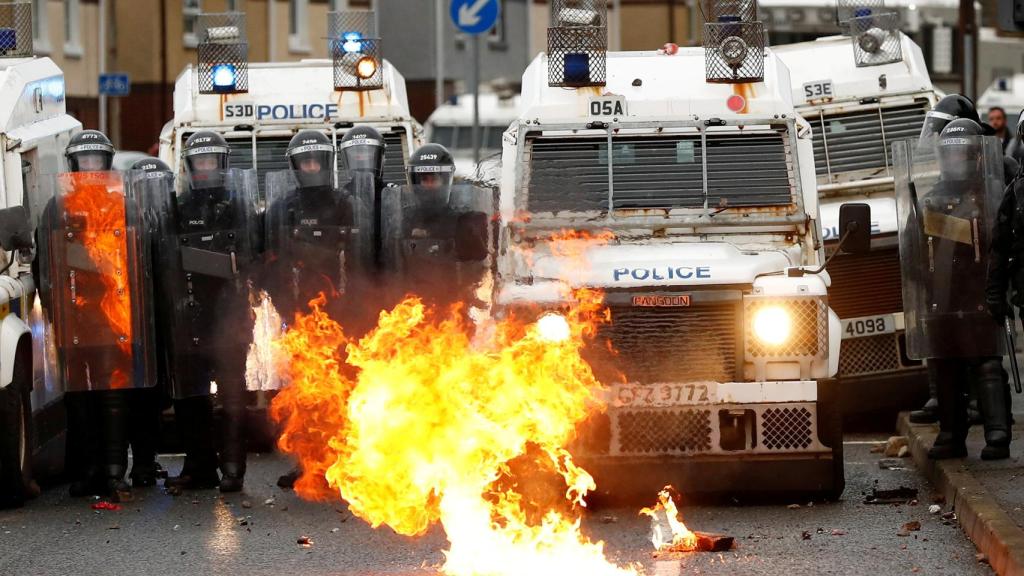 Policías frente a un fuego en Belfast.