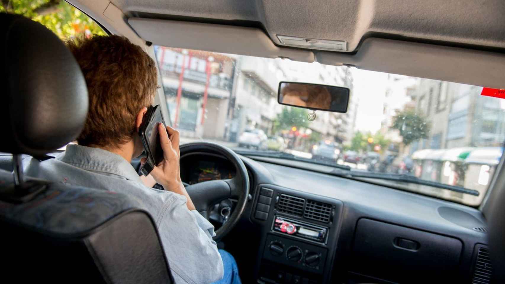 Un conductor utilizando el teléfono móvil en su coche.
