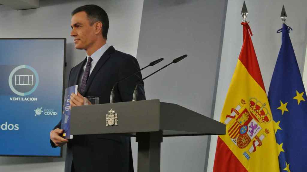 Pedro Sánchez posa con el documento del Plan de Recuperación en la sala de prensa de Moncloa.