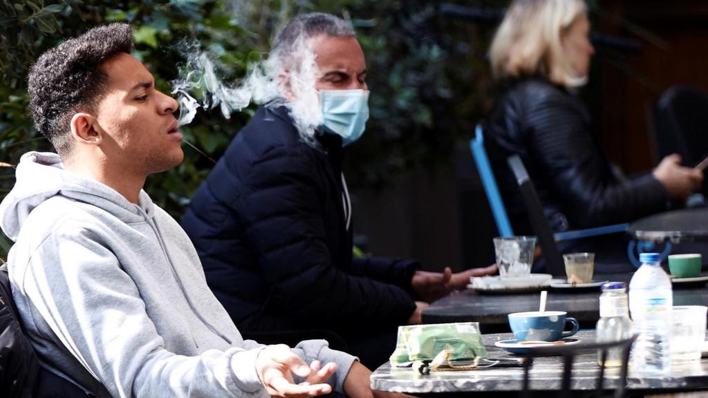 Un joven fumando en un bar de Barcelona.
