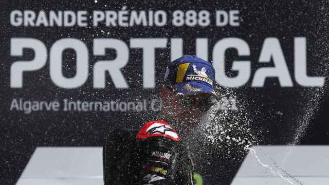 Fabio Quartararo es empapado con champán, en el podio del Gran Premio de Portugal.