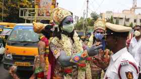 Figurantes caracterizados de dioses hindúes en una campaña por el uso de la mascarilla en Bangalore, India.