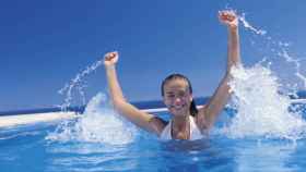 Una joven celebra en una piscina.