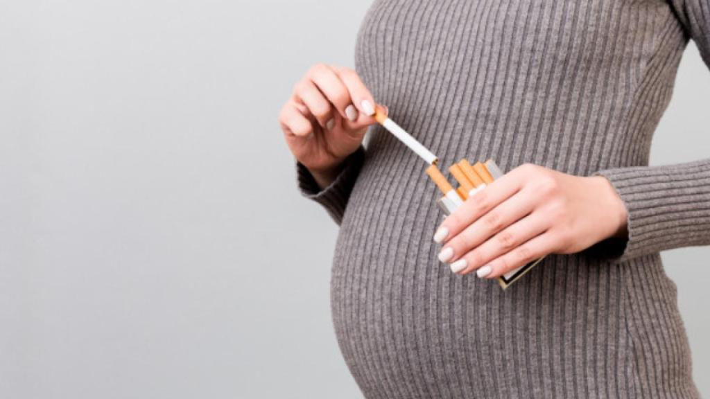 Una mujer embarazada con varios cigarrillos.