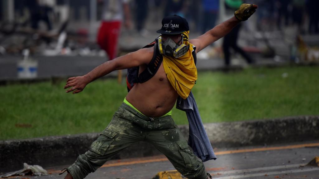 Manifestantes se enfrentan con miembros del Escuadrón Móvil Antidisturbios (ESMAD) durante las protestas en Cali .