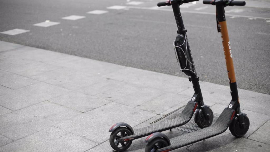 Dos patinetes eléctricos aparcados en la acera.