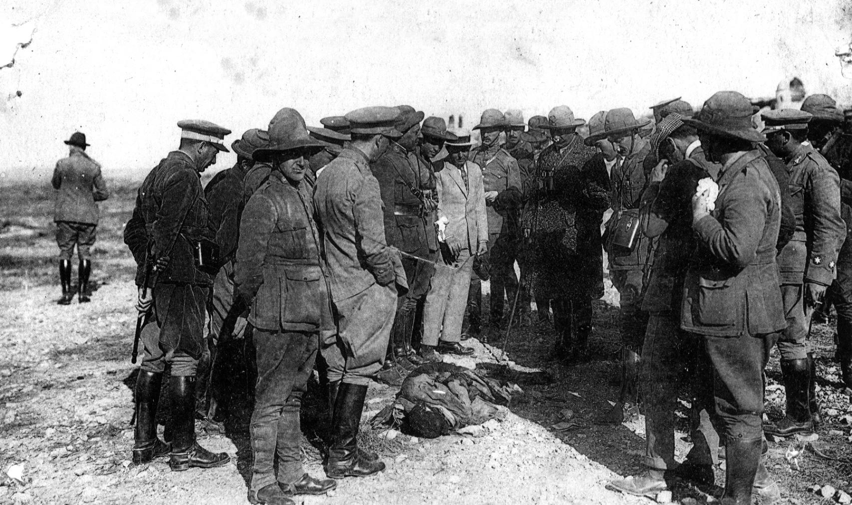 El alto comisario Dámaso Berenguer, rodeado de varias personas, contempla un cadáver encontrado con las manos atadas a la espalda tras los sucesos de Monte Arruit en 1921.
