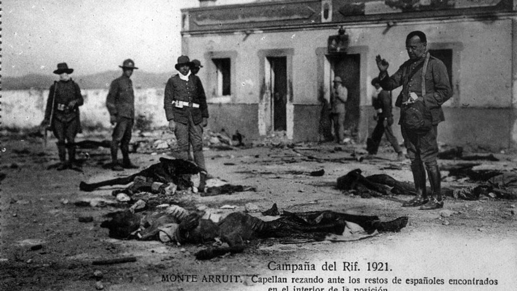 Un capellán reza ante los restos de los españoles encontrados muertos en Monte Arruit.