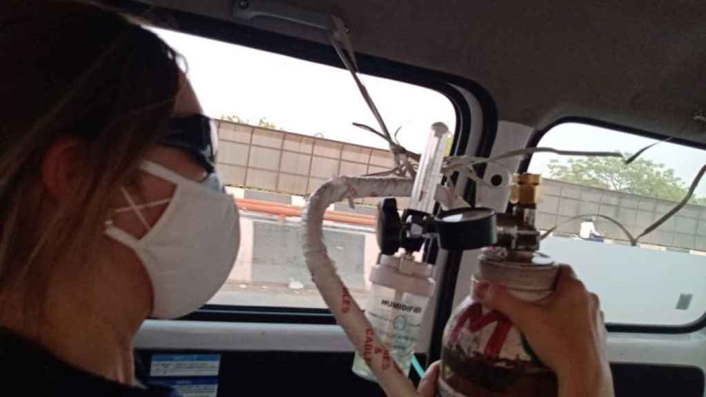 Momento del traslado de Pepa al hospital, en el interior de la ambulancia, donde una de sus amigas españolas sujeta una bombona de oxígeno.