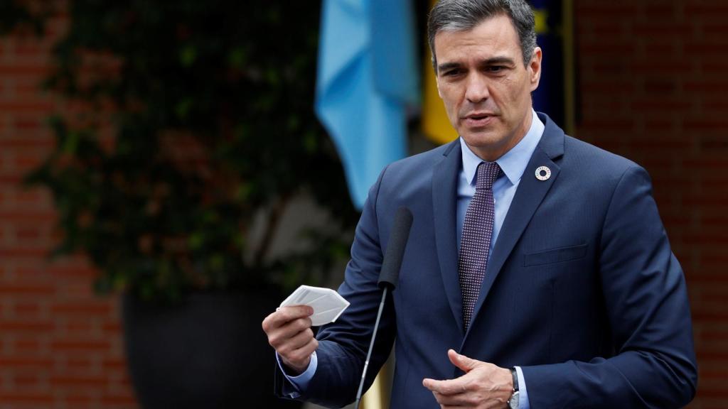 Sánchez, con la mascarilla en la mano, este martes en La Moncloa.