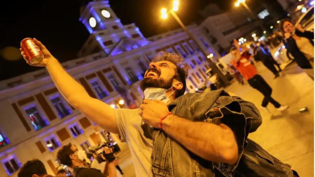 Un hombre brinda por el fin del estado de alarma en la Puerta del Sol de Madrid.