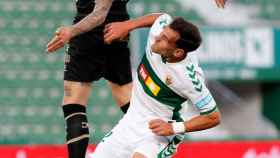 El delantero del Alavés, Joselu (i) pelea un balón con el defensa del Elche, Dani Calvo, durante el partido de Liga en Primera División.
