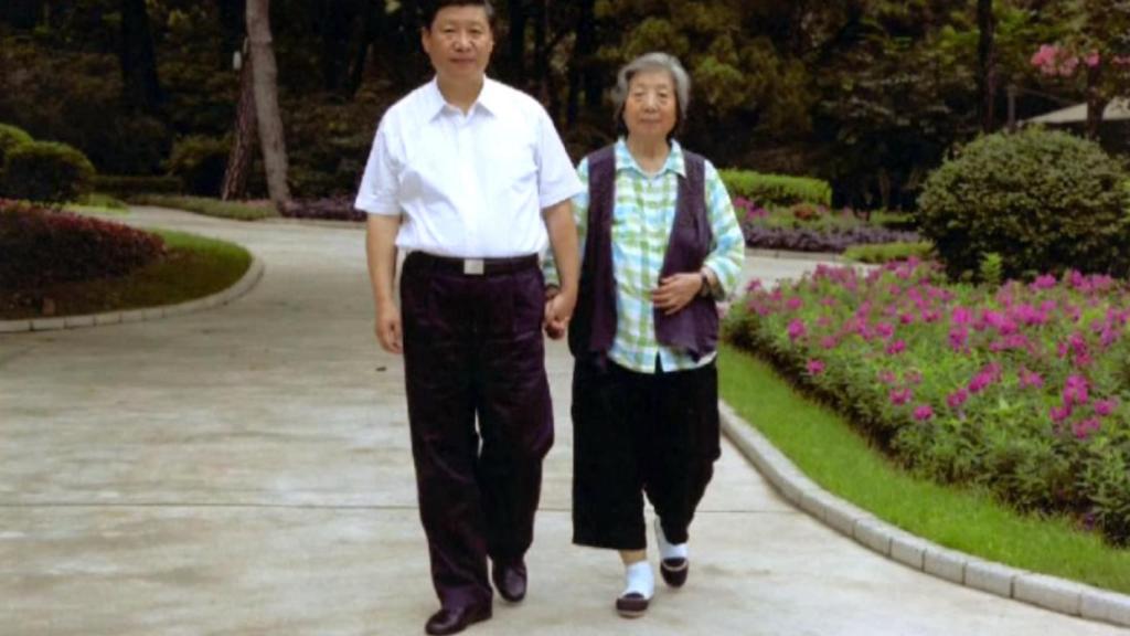Xi Jinping camina junto a su madre, Qi Xing.