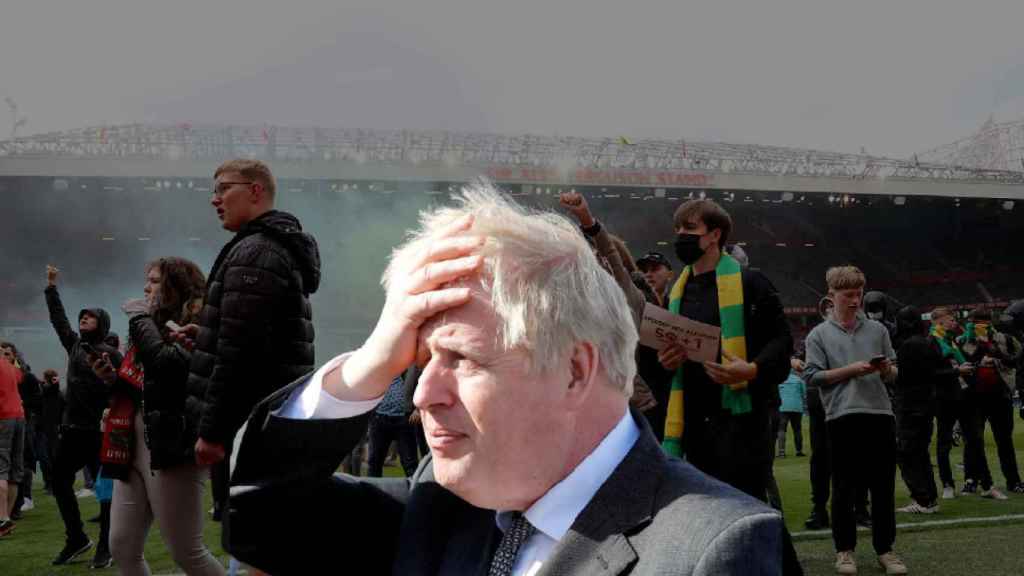 Boris Johnson, Primer Ministro de Reino Unido, con los altercados en Old Trafford de fondo